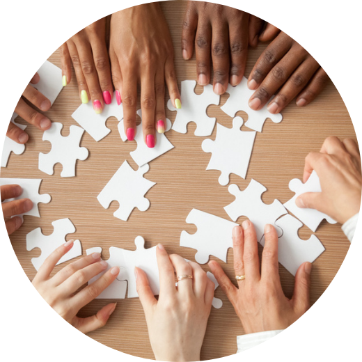 Many employee hands working together on a jigsaw puzzle